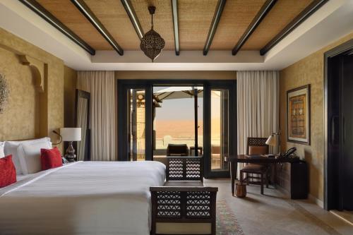a bedroom with a bed and a view of the ocean at Anantara Qasr al Sarab Desert Resort in Jurayrah