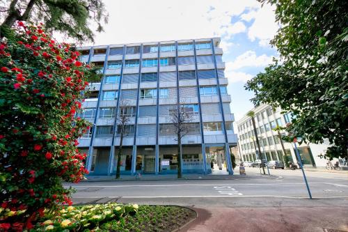 un alto edificio blu con fiori rossi di fronte di Casa Cupido- Happy Rentals a Locarno