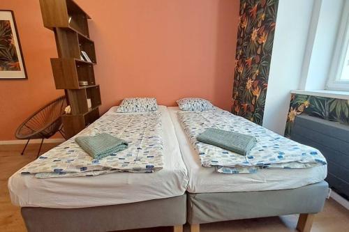 2 aparte bedden in een kamer met oranje muren bij Fun bright studio with flat screen TV in Praag