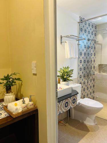 a bathroom with a sink and a toilet and a shower at Kemi House Hoi An in Hoi An