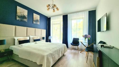 sypialnia z dużym łóżkiem i niebieskimi ścianami w obiekcie NOOK NOOK Apartments Kazimierza Wielkiego 104 w Krakowie