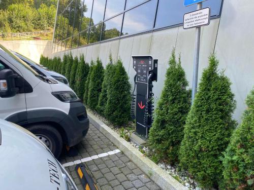 a parking lot with a parking meter next to trees at Hotel Meta Resort & Vine SPA in Szczyrk