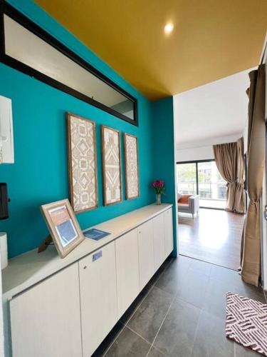 a living room with a blue wall and a table at Roxy Sematan Beach Townhouse Deluxe , 1 & 2 in Sematan