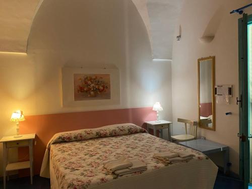 トッレ・サン・ジョヴァンニ・ウジェントにあるAraucariaのベッドルーム1室(ベッド1台、テーブル2台、鏡付)