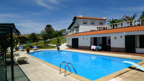 a swimming pool in front of a house at Quinta Do Forno in Vimeiro