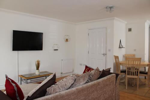 a living room with a couch and a table at Eldridge Court Apartment in Dagenham