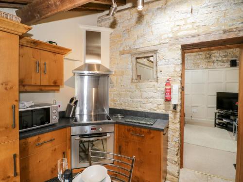 a kitchen with a stove and a microwave at Old Bothy in Shipston on Stour