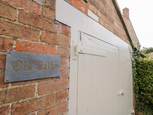 a brick building with a white garage door at Old Bothy in Shipston on Stour