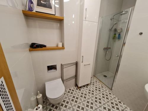 a white bathroom with a toilet and a shower at Fantastic Apartments - KP69 Room - A in Warsaw