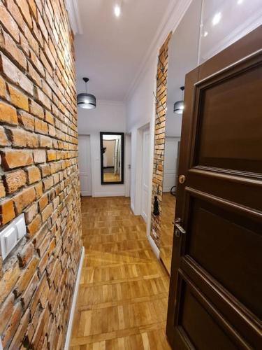 a hallway with a brick wall and a door at Fantastic Apartments - KP69 Room - A in Warsaw
