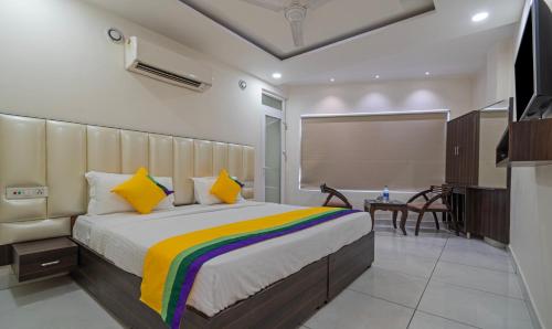 a bedroom with a large bed with a colorful blanket at Itsy Hotels P Grand in Ludhiana