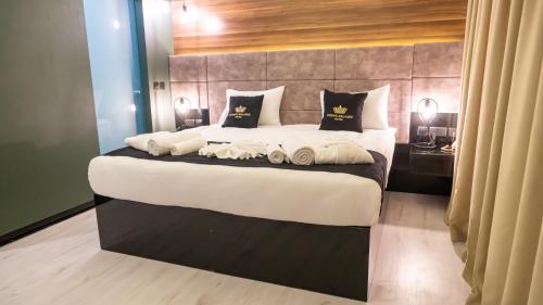 a bedroom with a large bed with two pillows at Crown Salamis Hotel in Mağusa
