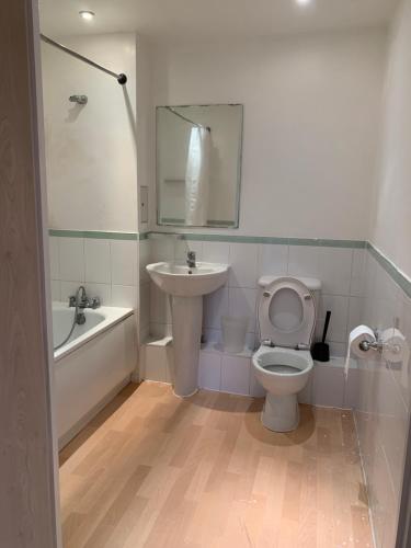 a bathroom with a sink and a toilet and a bath tub at North Acton Flat in London
