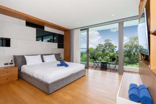 una camera con un letto e una grande finestra di Sea View Duplex per 5 in The Blue Point 88 Residence near Patong and Paradise Beach a Patong Beach