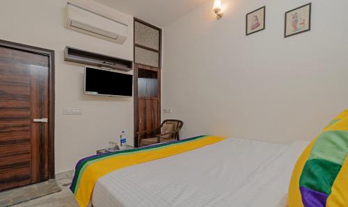 a bedroom with a bed and a tv on the wall at Itsy Hotels P Grand in Ludhiana