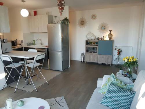 uma cozinha e sala de estar com uma mesa e um frigorífico em Cosy Bordeaux em Bordeaux