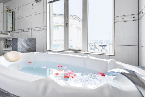 津市的住宿－Hotel Castle Inn Tsu，白色浴缸,里面装有红色的鲜花