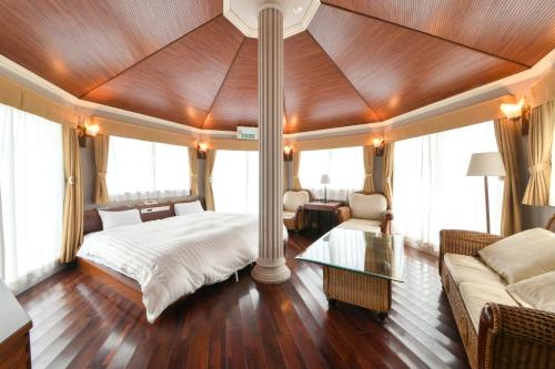 Hotel Castle Inn Tsu في تسو: غرفة نوم بسرير واريكة وطاولة