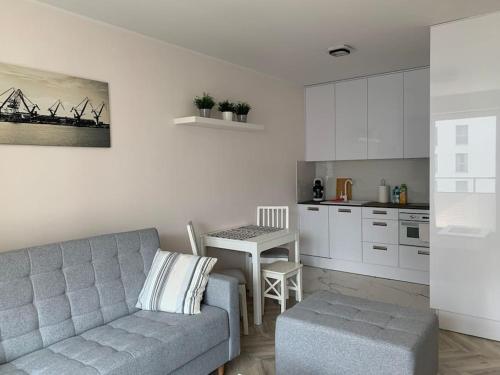 un soggiorno con divano e tavolo in cucina di Apart 89B Angielska Grobla 5 - Gdańsk Śródmieście a Danzica