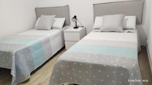 2 nebeneinander sitzende Betten in einem Schlafzimmer in der Unterkunft Apartamento agradable 2 in Madrid