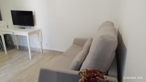 ein weißes Sofa im Wohnzimmer mit TV in der Unterkunft Apartamento agradable 2 in Madrid