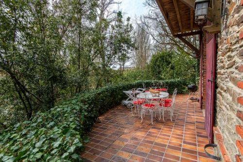 une terrasse en briques avec une table et des chaises. dans l'établissement L'Écrin de Verdure - Pavillon avec spa privatif, à Thouars