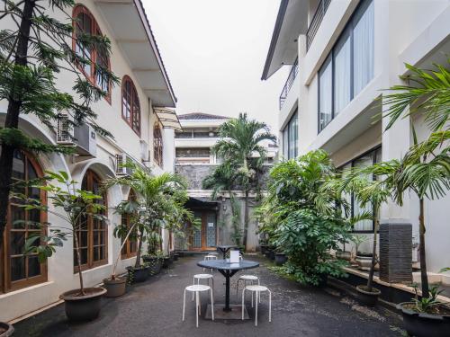 un patio en un edificio con mesa y sillas en Cove Arimbi en Yakarta