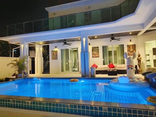a large swimming pool in the middle of a house at Wan D Villa Pattaya in Jomtien Beach
