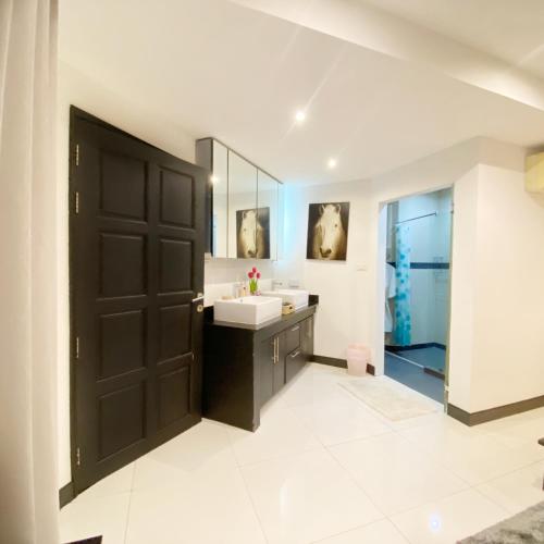 a bathroom with a black door and a sink at Wan D Villa Pattaya in Jomtien Beach