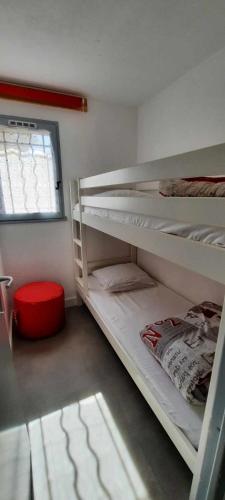 une chambre avec deux lits superposés et une fenêtre dans l'établissement Villa pinède - Proche naturiste, au Cap d'Agde