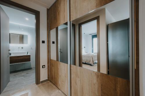 a bathroom with a large mirror and a sink at Pearl Apartel in Volos