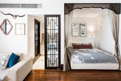 a bedroom with a bed and a couch at Shanghai Art Decor Suite W Nanjing Rd FFC in Shanghai