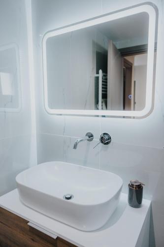 a bathroom with a white sink and a mirror at Pearl Apartel in Volos