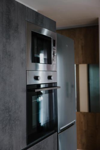 a kitchen with a microwave and a refrigerator at Pearl Apartel in Volos