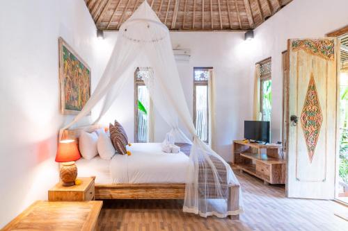 1 dormitorio con 1 cama con mosquitera en Villa Pranawa, en Ubud