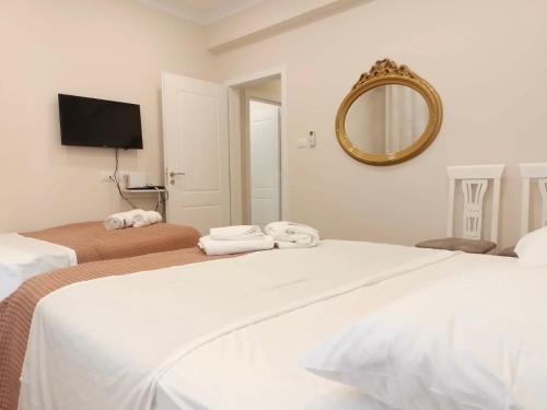 ein Hotelzimmer mit zwei Betten und einem Spiegel in der Unterkunft Serendipity Apartment in Tirana