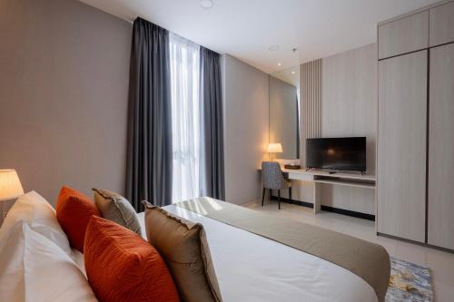 a hotel room with a bed and a television at Societe Hartamas by Lyfehaus in Kuala Lumpur