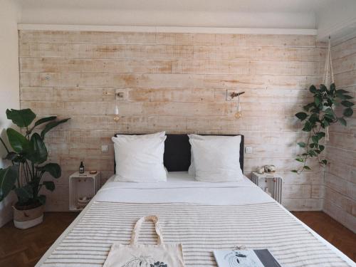 a bedroom with a white bed with a wooden wall at Villa Sayulita Surfhouse in Seignosse