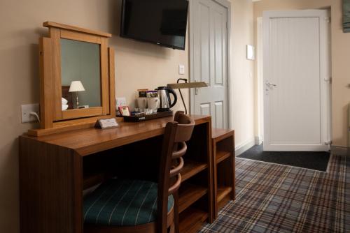 a hotel room with a desk and a mirror at The Lindisfarne Inn - The Inn Collection Group in Beal