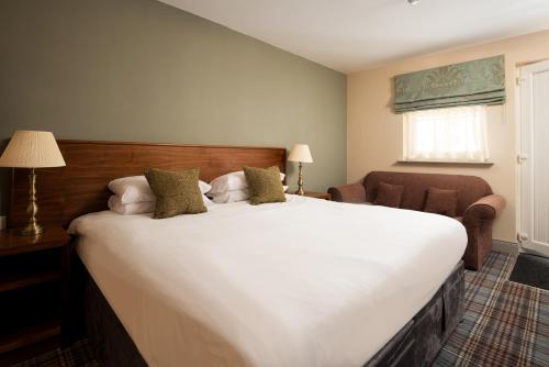 BealにあるThe Lindisfarne Inn - The Inn Collection Groupのベッドルーム(大きな白いベッド1台、椅子付)