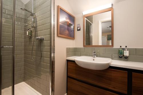 a bathroom with a sink and a shower at The Lindisfarne Inn - The Inn Collection Group in Beal