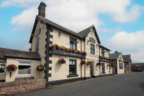 a building with flower boxes on the side of a street at The Lindisfarne Inn - The Inn Collection Group in Beal