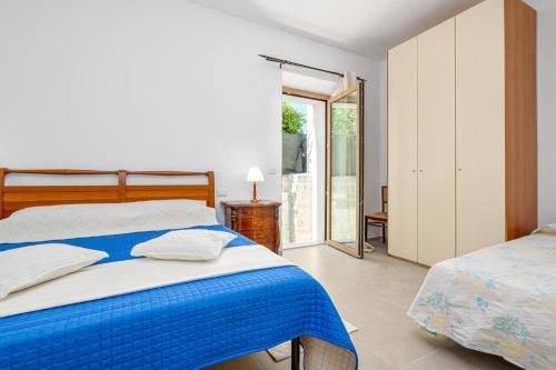 Un dormitorio con una cama azul y blanca y una ventana en La Vecchia Posta, en Telti