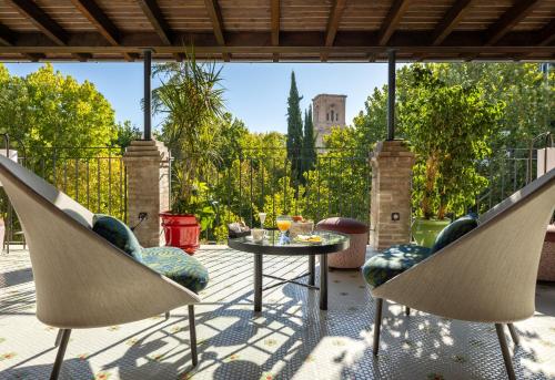 a patio with two chairs and a table on a patio at Seda Club Hotel - Small Luxury Hotels in Granada