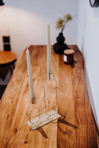a wooden table with two candle holders on it at Pearl Apartel in Volos
