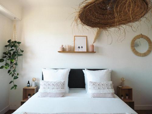a bedroom with a white bed with two pillows at Villa Sayulita Surfhouse in Seignosse