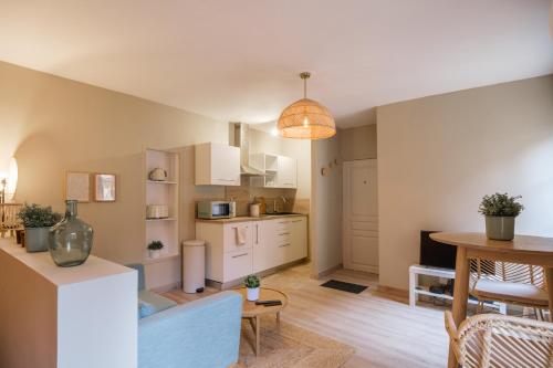 a kitchen and living room with a couch and a table at La Rousserolle de Sarlat in Sarlat-la-Canéda