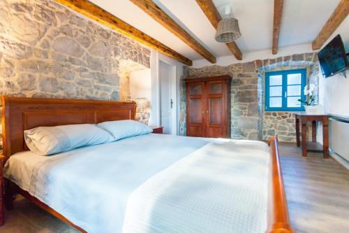 una camera da letto con un letto e un muro di pietra di Villa Lusa a Bajčići