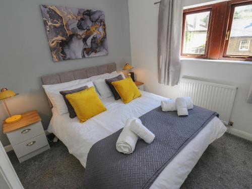 um quarto com 2 camas com almofadas amarelas e brancas em Cheshire House em Castleton