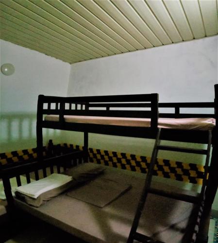 a bunk bed with a chair in a room at BnT Inn in Mactan